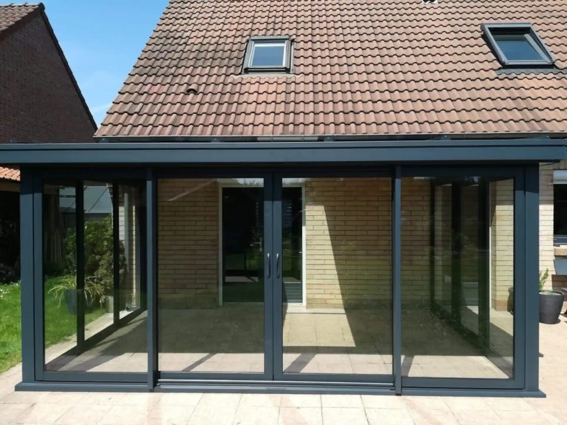 une-rallonge-de-toit-en-aluminium-gris-avec-une-porte-en-ver Véranda dans les hauts de fance par plastique 2000